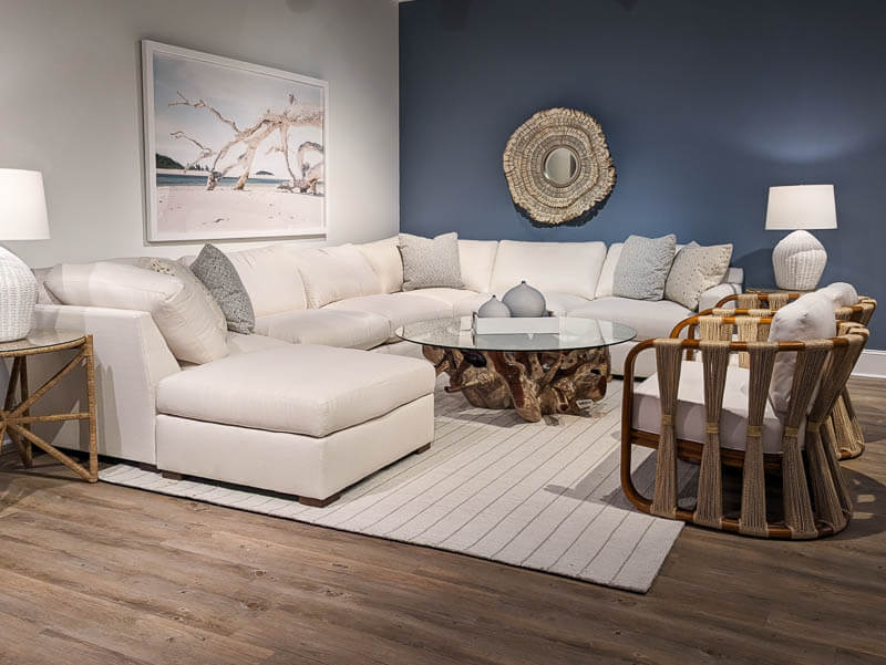 Modern Coastal White L shaped sofa against a blue wall with a branch coffee table